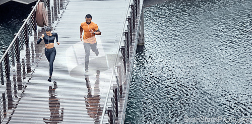 Image of Overhead, fitness and man with woman running as exercise on city promenade training or workout outdoors in a town. Athlete, runner and fit male sprint fast for wellness, cardio and health by water