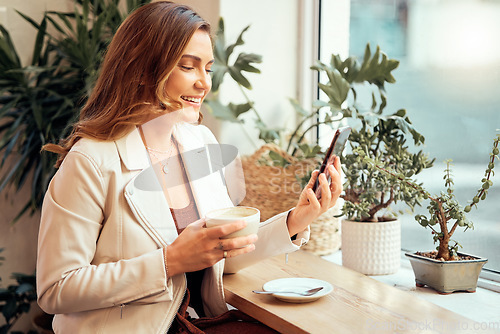 Image of Coffee shop, phone and social media with a woman customer drinking while typing a text message by a window. Internet cafe, mobile and communication with a female enjoying a drink in a restaurant