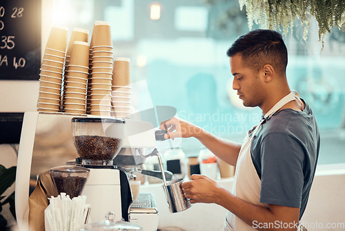 Image of Coffee shop, barista and service with a man at work using a machine to pour a drink in the kitchen. Cafe, small business and waiter with a male employee working in a restaurant to prepare a beverage