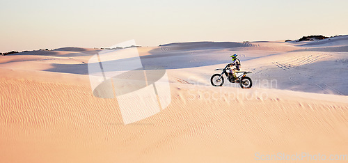 Image of Desert, nature and athlete riding a motorcycle for exercise, fitness or skill training in nature. Extreme sports, action and male athlete on a bike for an outdoor workout in the sand dunes in Dubai.