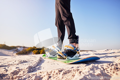 Image of Sandboard, sports and athlete in the desert sand with hills for exercise, competition or training. Fitness, travel and man on a board in a dune for a workout while on vacation or adventure in Dubai.