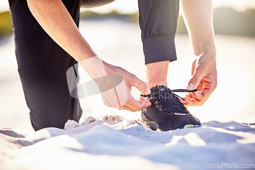 Image of Hands, shoes and tying lace on sand for running exercise, travel or workout outdoors. Hand of sporty person tie shoe for run, exercising or training in preparation or getting ready for active cardio