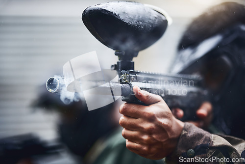 Image of Hand, paintball and gun with a sports man playing a military game for training or fun outdoor. Fitness, exercise and safety with a male player using a marker to shoot during a competitive tournament