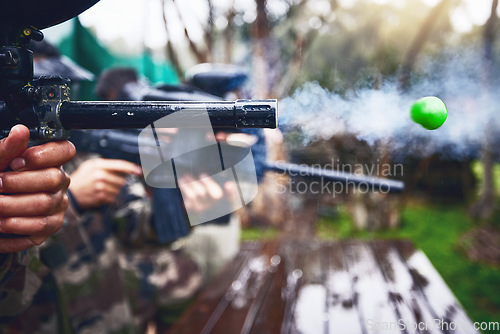 Image of Explosion, shooting and person with paintball gun, ball and closeup of fun, extreme and sport, fitness and training. Zoom, marker, and target, practice and game with people competing