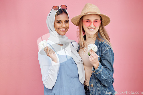 Image of Friends, diversity and fashion women portrait with spring flowers on a pink background with a happy smile. Muslim woman and girl together for hug, love and support for lgbt freedom, respect and pride