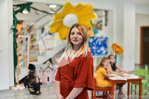 Image of Portrait of a teacher in a preschool institution, in the background of the classrooms