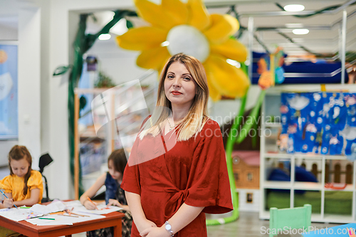 Image of Portrait of a teacher in a preschool institution, in the background of the classrooms