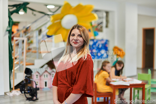 Image of Portrait of a teacher in a preschool institution, in the background of the classrooms