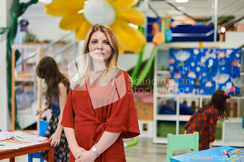 Image of Portrait of a teacher in a preschool institution, in the background of the classrooms