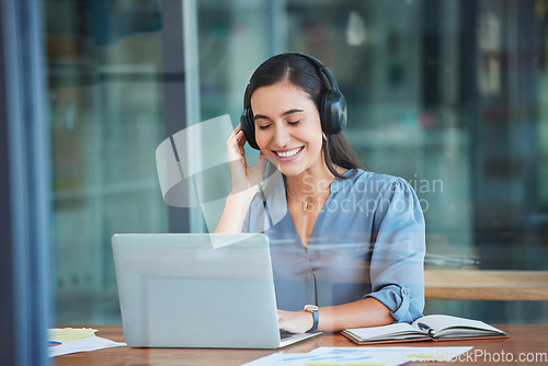 Image of Business woman, laptop and headphones for music while working at office desk, agency or company. Happy worker listening to radio, audio or sound on computer, internet and online podcast on technology