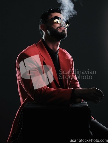 Image of Man in red suit, smoking and fashion with style, trendy and guy on dark studio background. Mafia, male and gentleman with elegant outfit, edgy and cigarette with glamour, fancy and black backdrop