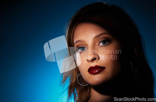 Image of Portrait, makeup and woman isolated on blue background in beauty, cosmetics and glamour, gradient color or neon light. Skincare, fashion and creative model face or person in studio with mockup space