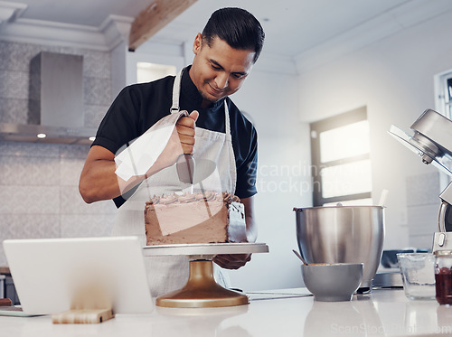 Image of Piping, decorating and man baking a cake with chocolate in a kitchen or pastry chef happy with online recipe. Food, desert and cook preparing a sweet meal in Brazil and using a tablet