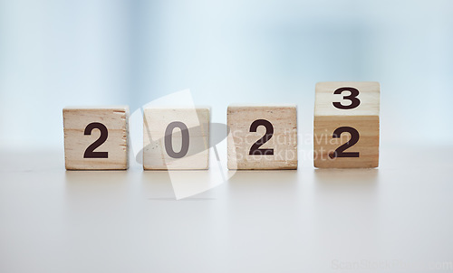 Image of Calendar, 2023 countdown and wooden blocks on empty table in grey studio background for goals or resolution. New year, celebrate and start for corporate growth or new change motivation with toy block