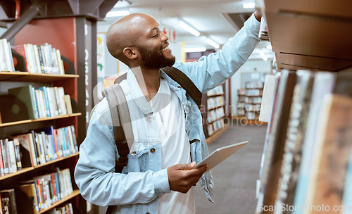 Image of Black man, student and library bookshelf of a university, college and knowledge center. Notebook, happy young person and smile of a male with books for learning and study research info at school