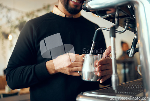 Image of Hands, barista and brewing coffee in kitchen using machine for hot beverage, caffeine or steam. Hand of employee male steaming milk in metal jug for premium grade drink or self service at cafe