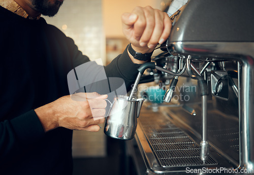 Image of Hands, man and barista brewing at coffee shop using machine for hot beverage, caffeine or steam. Hand of employee male steaming milk in metal jug for premium grade drink or self service at cafe