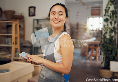 Image of Tablet, small business and woman in pottery workshop for ceramic startup, research and online website. Creative art, ecommerce and asian lady with tech to sell clay, sculpture and handmade products