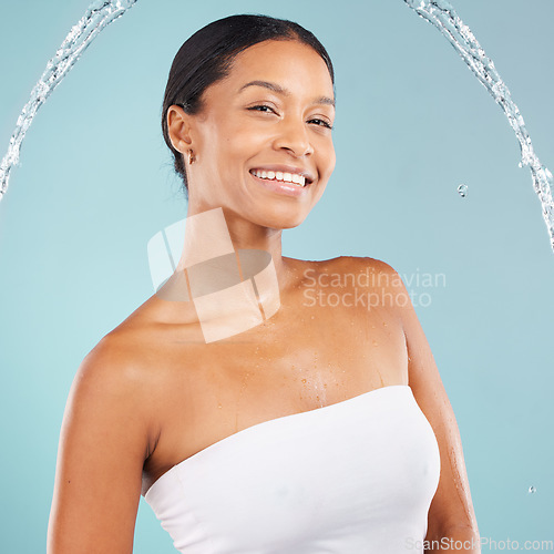 Image of Smile, water splash and beauty portrait of black woman in studio, body cosmetics and blue background. Face of female model, shower drops and spa for healthy skincare, wellness and cleaning aesthetics