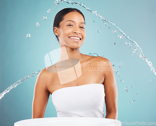 Image of Water splash, bathroom and portrait of black woman on blue background, studio and beauty cosmetics. Face of happy female model, shower and cleaning for healthy skincare, wellness and facial aesthetic