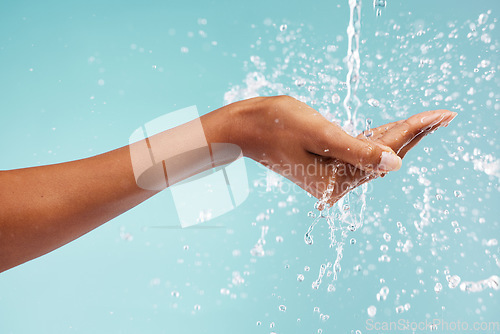 Image of Hands, woman and water splash for washing, skincare and healthy beauty on studio background. Closeup of person cleaning body, drops and palm in bathroom for wellness, shower and aesthetic self care