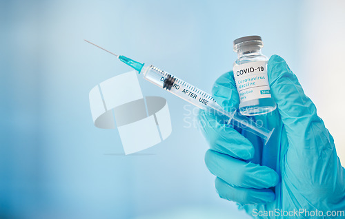 Image of Doctor, hands and syringe with covid vaccine for cure, healthcare or medical medication to combat virus. Hand of nurse holding corona virus sample with needle for vaccination from illness or disease