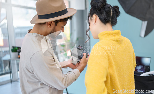 Image of Photography, camera and photographer talking to a model while looking at pictures from a photoshoot. Discussion, studio and young cameraman choosing a image with a woman in a creative artistic studio