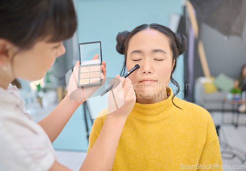 Image of Makeup, artist and woman in studio with professional, cosmetics and creative, product and glamour. Asian, face and model with artistic makeover specialist, backstage for beauty, eyeshadow or contour