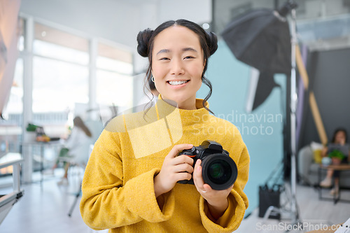 Image of Smile, camera and portrait of a photographer working at a studio for a photoshoot. Happy, media and creative Asian woman shooting, filming or learning about photography production as a career