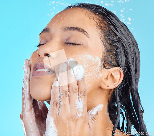 Image of Shower foam, face and black woman cleaning with water liquid for hydration, beauty healthcare soap or skincare hygiene. Self care studio, spa salon and relax model washing isolated on blue background