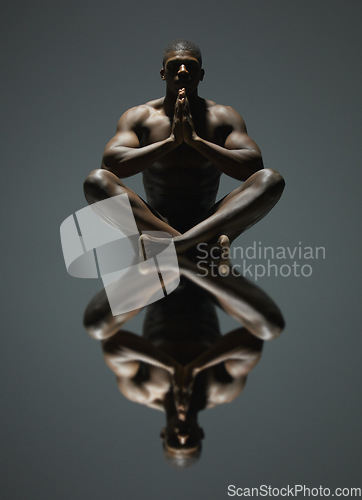 Image of Black man, yoga and meditation art with mirror reflection on dark background for spiritual wellness. Portrait of naked, nude or bare African American male model sitting and meditating in symmetry