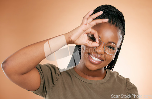 Image of Black woman, portrait smile and ok hand sign fro perfect, great or right against studio background. Happy African American female smiling in happiness showing okay emoji gesture for positive attitude