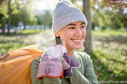 Image of Plastic bag, park and happy woman cleaning for earth day, planet or community service, support or volunteering. Recycle, sustainability and nonprofit, ngo person idea in nature forest for pollution