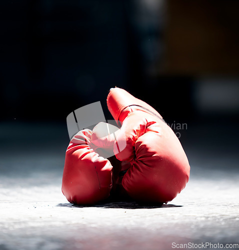 Image of Boxing gloves, floor and sports on a dark background in studio for health, competition or exercise. Fitness, leather and protective sportswear for a boxer or athlete in competitive fighting
