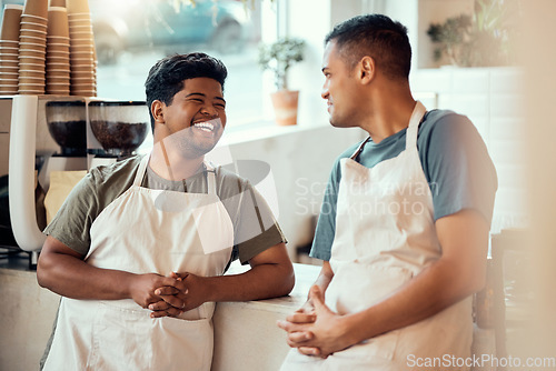 Image of Coffee shop, happy and male barista talking to his colleague before work at a restaurant or cafe. Happiness, smile and men waiter or server in discussion or conversation at the counter by cafeteria.