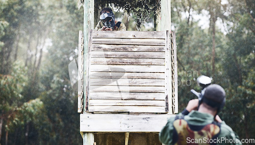 Image of Paintball, aim and man shooting while playing a action match on an outdoor battlefield competition. Focus, gear and male military soldier player aiming to shoot with a weapon at a game at an arena.