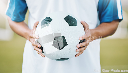 Image of Hands, ball and soccer player ready for sports match, game or competition on the outdoor field. Hand holding round sphere object for sport, training or practice in physical activity outside in nature