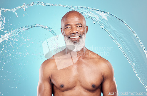 Image of Senior, water splash and portrait of a black man in studio shower for skincare and beauty. Smile, blue background and isolated elderly person with happiness for body cleaning and morning dermatology