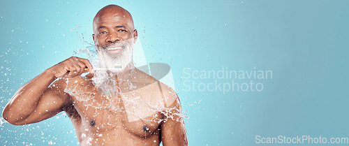 Image of Water splash, dental and black man with toothbrush, mockup and smile on face isolated on blue background space. Teeth, toothpaste and product placement, happy senior in studio portrait cleaning mouth