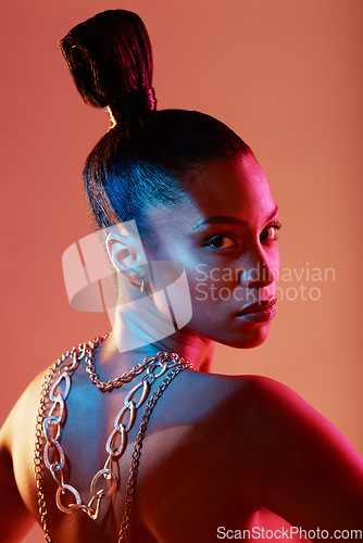 Image of Beauty, jewellery and portrait of a woman in a studio with neon lights for aesthetic and cosmetics. Makeup, art and young female model with a cosmetic routine with jewelry posing by orange background