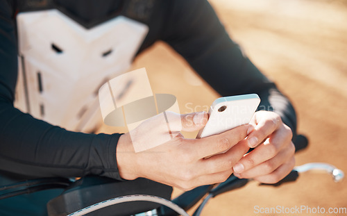 Image of Moto cross, phone and man hands on a motorcycle and adventure dirt road outdoor for sports. Fitness, workout and athlete hand zoom of a young person texting or on motorcycle social media app