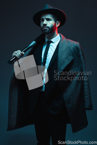 Image of Fashion, criminal and man in studio with bat for vintage, retro and Victorian gangster on dark background. Crime aesthetic, thinking and male model with luxury clothes, designer and elegant suit