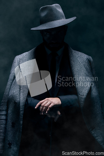 Image of Mafia, fashion and mystery man in a suit isolated on a dark background in a studio. Business, vintage and stylish secret businessman for crime investigation, spy work and agent on a backdrop