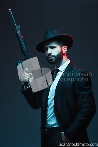Image of Man, suit or automatic rifle on dark studio background in secret spy, isolated mafia or crime lord security. Model, gangster or thinking hitman and gun in stylish, trendy or fashion clothes aesthetic