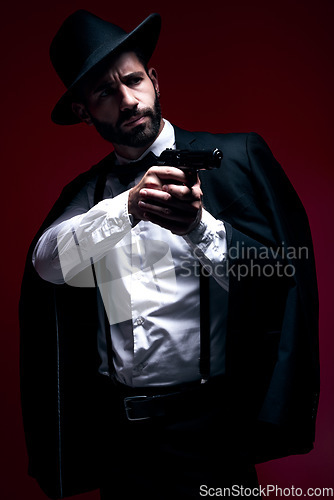 Image of Assassin, suit or shooting gun on studio background in dark secret spy, isolated mafia leadership or crime security. Model, gangster or hitman weapon in aim, formal style or fashion clothes aesthetic