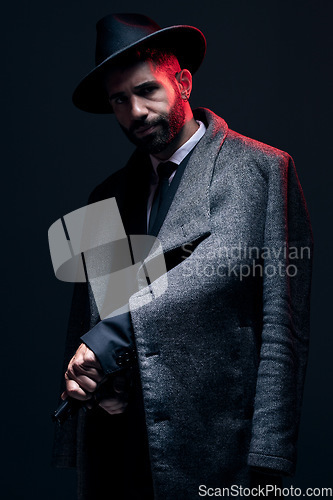 Image of Gangster, portrait and holding gun on studio background in dark secret spy, isolated mafia leadership or crime lord security. Model, man and hitman suit weapon in formal or fashion clothes aesthetic