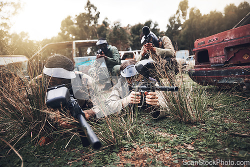 Image of Paintball, camouflage and team playing a match for fun, fitness and extreme sports with guns. Army, weapons and group of military people practicing or training for a game on an outdoor battlefield.