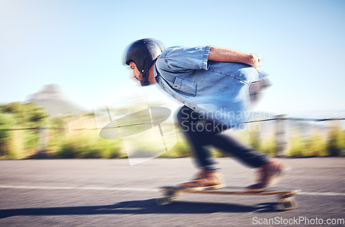 Image of Skateboard, sports man and skating fast on road for fitness, exercise or wellness. Training, freedom and travel adventure of skater person moving with speed, balance and safety outdoor on asphalt