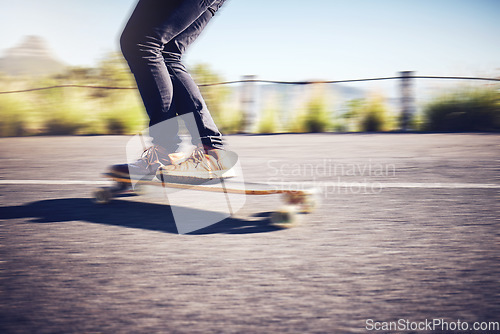 Image of Fast, blur and legs of a man on a skateboard in street for exercise, training and travel in Australia. Fitness, sports and legs of a person skateboarding in the city road for fun, speed and cardio