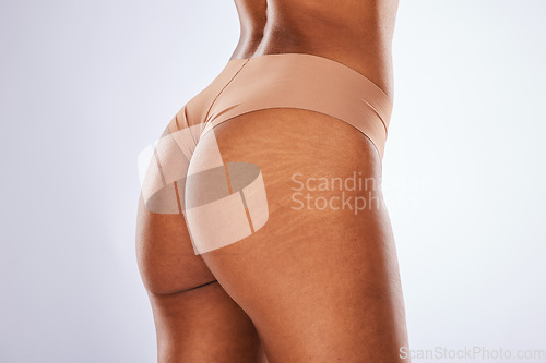 Image of Cellulite, buttocks and underwear with a model black woman in studio on a gray background for body positivity. Stretch marks, real and natural with a female posing in lingerie from the back